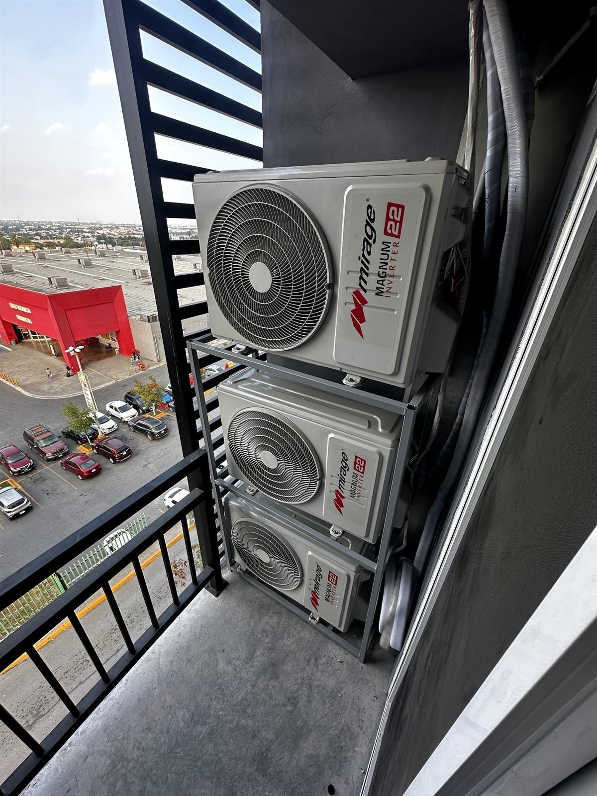 Tres condensadoras inverter apiladas en el balcón de un departamento